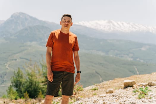 Portrait of Young man standing on Mountain View. Male on mountain background.