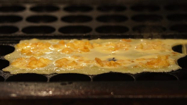 The cooking of Takoyaki. The popular Japanese street food that consists of small, ball-shaped snacks made of batter and filled with small pieces of octopus and other ingredients.