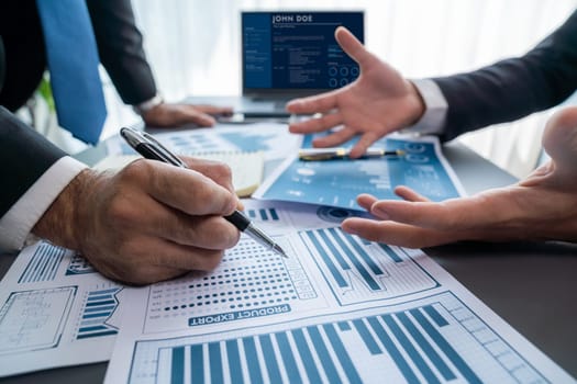 Closeup busy analyst team discussing financial data on digital dashboard, analyzing chart and graph using data science software display on a laptop screen. Business intelligence and Fintech. Fervent