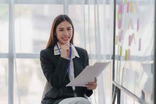 Asian Business person makes analysis and research financial report at office, analyzes profits. Accountant checks status of financial.