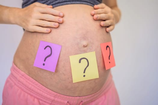 Choosing baby name. Confused pregnant woman with question marks on paper stickers on tummy.