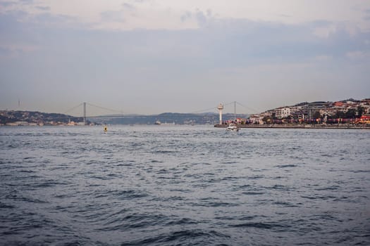 Istanbul at sunset, Turkey. Tourist boat sails on Golden Horn in summer. Beautiful sunny view of Istanbul waterfront with old mosque. Concept of travel, tourism and vacation in Istanbul and Turkey. Turkiye.