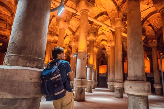 Man tourist enjoying Beautiful cistern in Istanbul. Cistern - underground water reservoir build in 6th century, Istanbul, Turkey, Turkiye.
