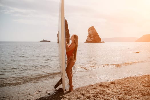 Close up shot of beautiful young caucasian woman with black hair and freckles looking at camera and smiling. Cute woman portrait in a pink bikini posing on a volcanic rock high above the sea