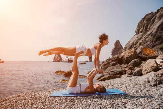 Woman sea yoga. Back view of free calm happy satisfied woman with long hair standing on top rock with yoga position against of sky by the sea. Healthy lifestyle outdoors in nature, fitness concept.