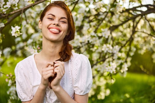 portrait of an emotional woman showing her tongue in a blooming garden. High quality photo