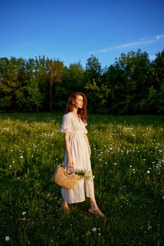 a beautiful woman in a light, light, summer dress is standing in a flowering meadow in the sunset light. High quality photo