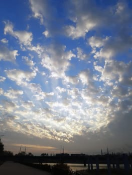 City high-speed tram on the bridge against the background of the morning sky and the rising sun.