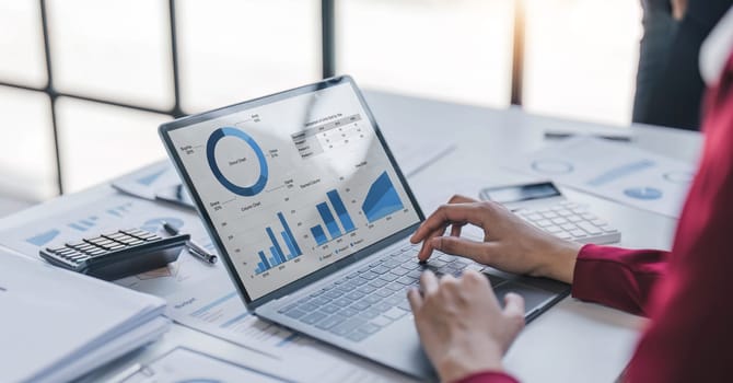 Close up Businesswoman using calculator and laptop for calculating finance, tax, accounting, statistics and analytic research concept..