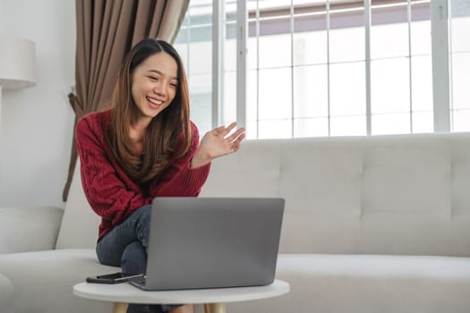 Satisfied asian woman relaxing on comfortable couch, using laptop at home, happy girl chatting with friends in social network, spending lazy weekend, watching movie, shopping online, writing email..