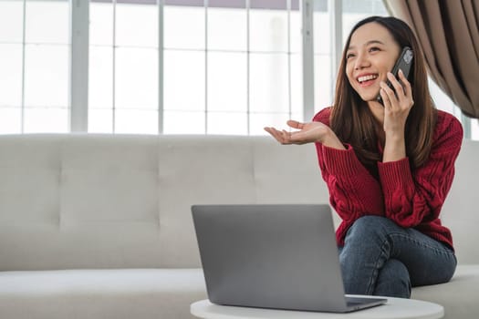 Satisfied asian woman relaxing on comfortable couch, using laptop at home, happy girl chatting with friends in social network, spending lazy weekend, watching movie, shopping online, writing email..