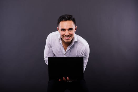 Cheerful young guy 20s in classic shirt isolated on a dark wall background studio portrait.