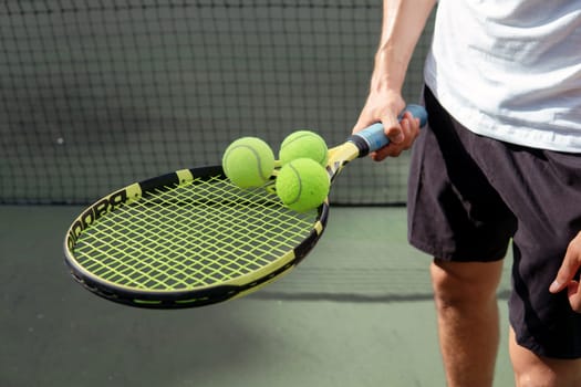 close-up. male hands holding tennis racket and balls. bali