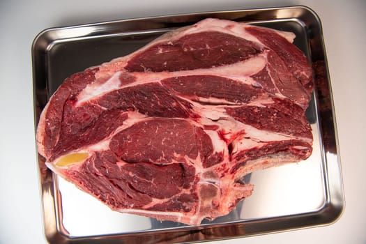 Raw cowboy steak with seasonings on white background, prime rib eye on bone, High quality photo