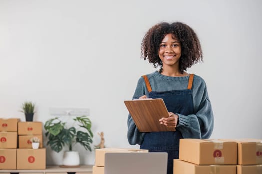 Shipping shopping online ,young start up small business owner writing address on cardboard box at workplace.small business entrepreneur SME or freelance asian woman working with box at home..
