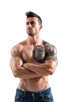 Handsome shirtless athletic man in jeans, with arms crossed on muscular chest, looking away in studio shot, isolated on white background
