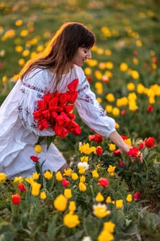 Woman field tulips sunset. Woman against sunset and wild tulip flowers, natural seasonal background. Multi-colored tulips Tulipa schrenkii in their natural habitat are listed in the Red Book