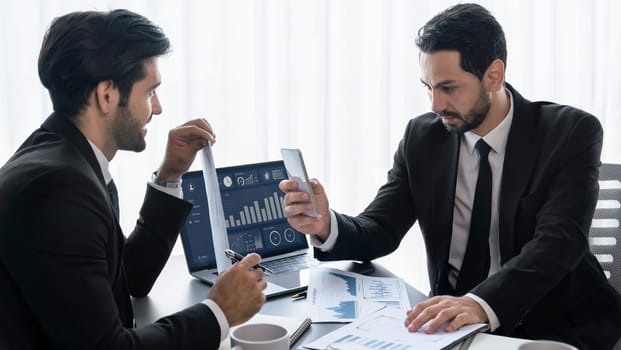 Busy analyst team discussing financial data on digital dashboard, analyzing chart and graph using data science software display on a laptop screen. Business intelligence and Fintech. Fervent