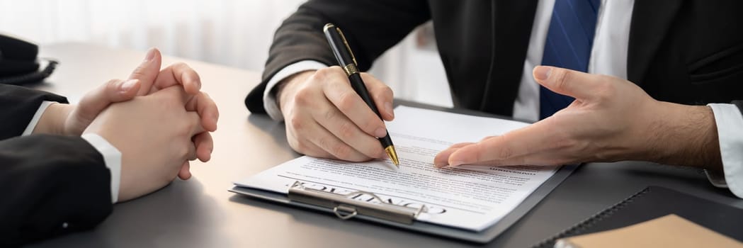 Closeup businessman sign contract or legal document with pen in his hand during corporate meeting for business deal or legal executive decision to pay off a loan or filing for bankruptcy. Equilibrium