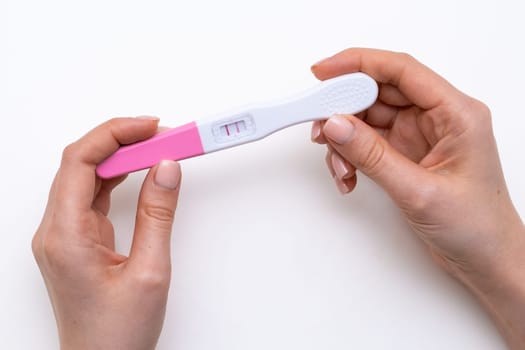 Pregnancy test in the woman hands on the white background.