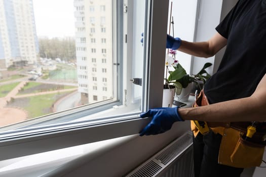 Man in a blue shirt does window installation. High quality photo