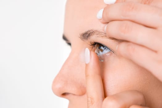 Side view of young woman applying contact lenses. Better vision concept.