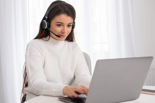 A young beautiful woman with headphones is engaged in online education. Teaching online concept