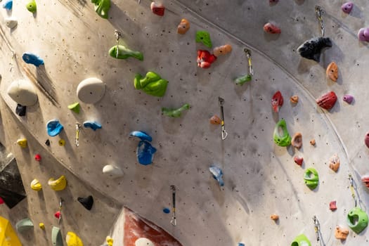 Artificial rock climbing wall with various colored grips.