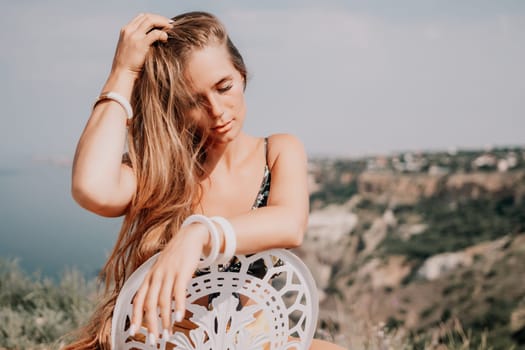 Happy woman portrait in cafe. Boho chic fashion style. Outdoor photo of young happy woman with long hair, sunny weather outdoors sitting in modern cafe