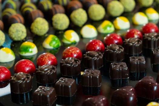 Colorful chocolate candies with different flavors. Exclusive delicious handmade sweets.