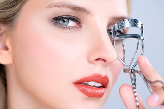 Closeup alluring facial makeup, beautiful woman with perfect smooth cosmetic clean skin correct eyelash curler with metal mechanic beauty accessory in isolated background.