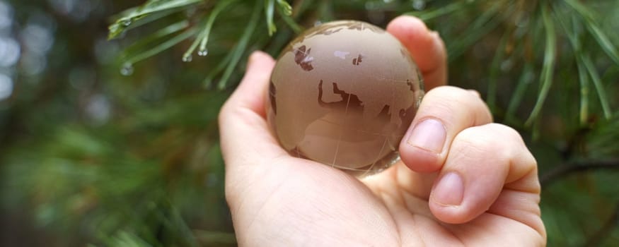 Environment concept. World earth day. Hands are holding a glass planet.