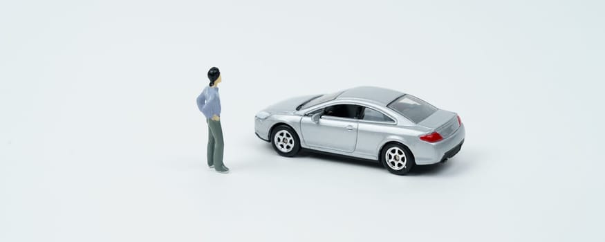 Industry and technology concept. On a white surface is a car and a miniature figurine of a man looking at the car.