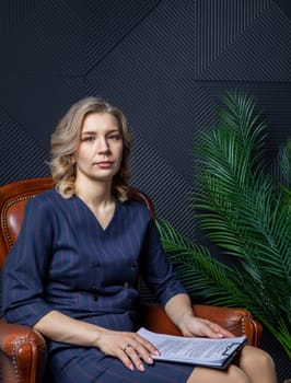 Portrait of a successful female psychologist in her office, notebook in hand