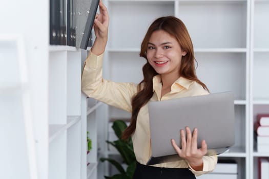 Asian Business person makes analysis and research financial report at office, analyzes profits. Accountant checks status of financial.