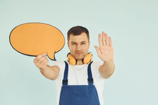 With big headphones on neck. Man standing in the studio with empty signs for the text.