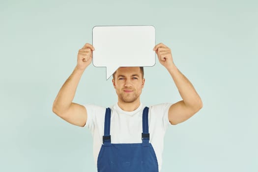 Worker saying something. Man standing in the studio with empty signs for the text.
