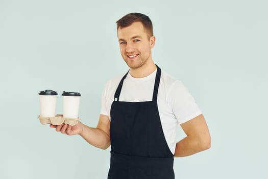 Man in uniform standing in the studio with drinks in hands.