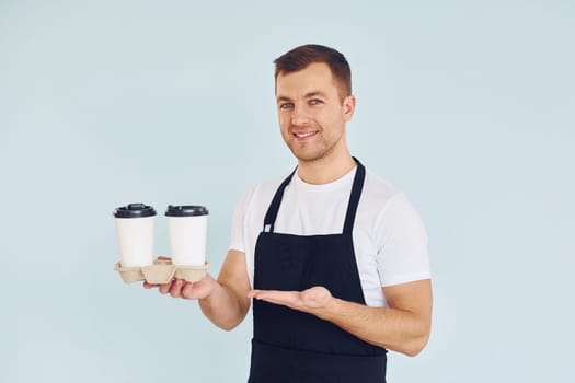 Man in uniform standing in the studio with drinks in hands.