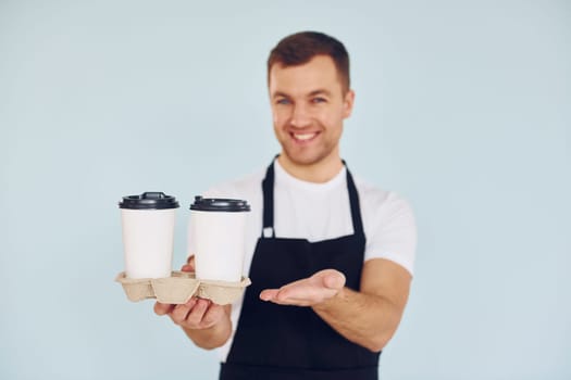 Man in uniform standing in the studio with drinks in hands.