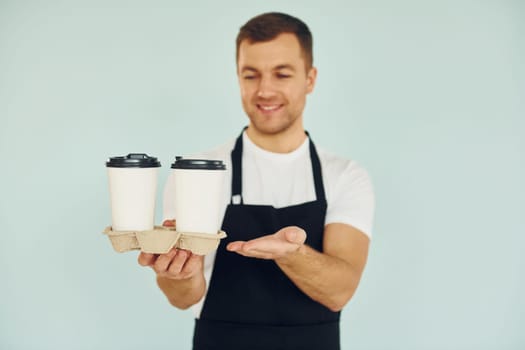 Man in uniform standing in the studio with drinks in hands.