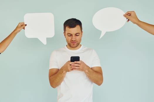 Conversation text. Man standing in the studio with empty signs.