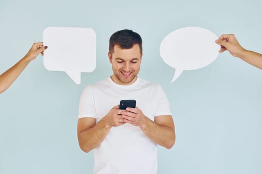 Conversation text. Man standing in the studio with empty signs.