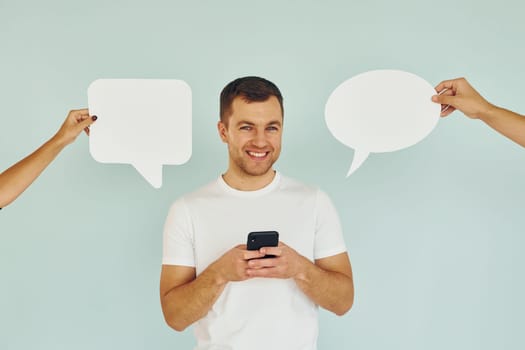 Conversation text. Man standing in the studio with empty signs.