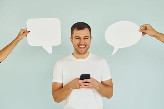 Conversation text. Man standing in the studio with empty signs.