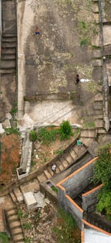 Unrecognizable children playing and chasing each other in a favela, as seen from a high angle view.
