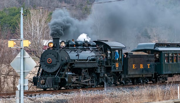 Rockhill, Pennsylvania, February 2, 2023 - View of a Narrow Gauge Restored Steam Passenger Train Blowing Smoke and Traveling Thru Farmlands on a Winter Day
