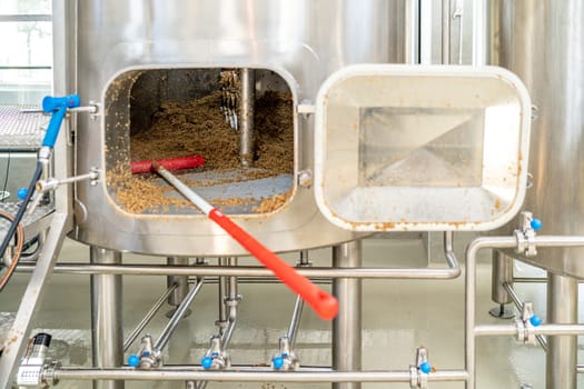 cleaning the boiler from residual malt after brewing beer in the brewery.