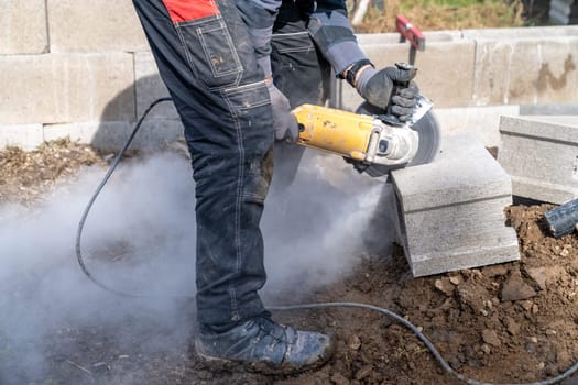 cutting concrete bricks with an electric grinder.