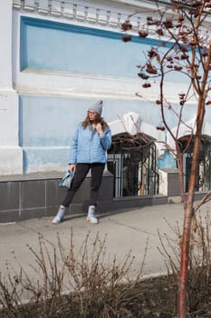 Portrait of a stylish woman in blue jacket. Spring outdoor portrait.